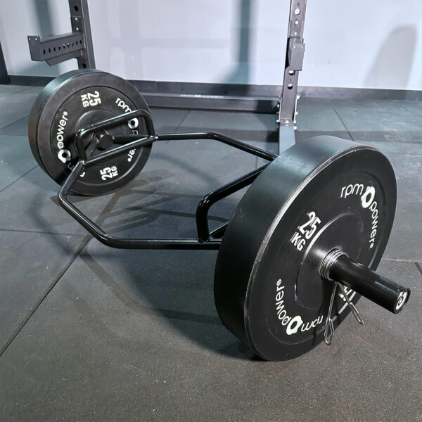 Olympic Trap Bar & 25kg weightlifting Bumper Plates lying on the gym floor of a home gym